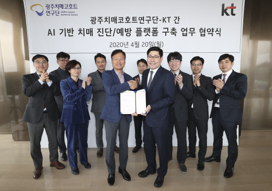 KT와 조선대 광주치매코호트연구단 관계자들이 양해 각서 체결 후 기념촬영을 하고 있다. 윤동식(왼쪽) KT 클라우드·DX 사업단 전무와 이건호 조선대 광주치매코호트연구단 단장이 악수하고 있다.  KT 제공